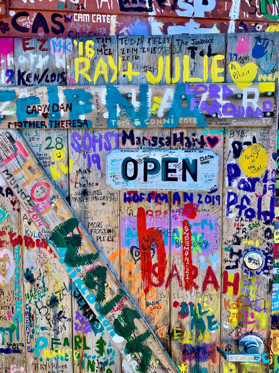 close up of wooden door with peoples signatures in different colors